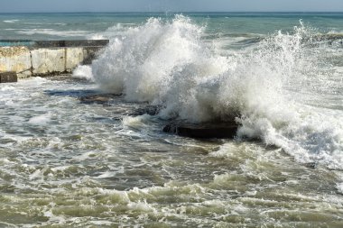 Deniz dalgaları karşı kayalar atan.