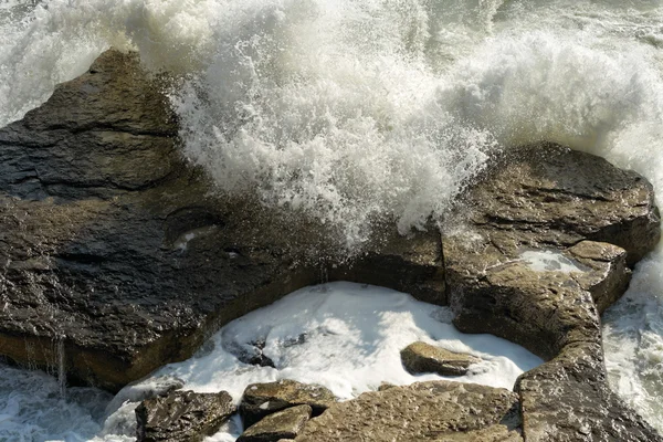 Zee golven tegen de rotsen te verslaan. — Stockfoto
