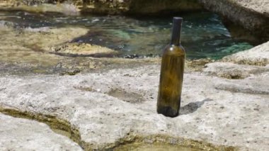 Bottle of wine on the rocky seashore. Caspian Sea. 07 June 2022 Year.