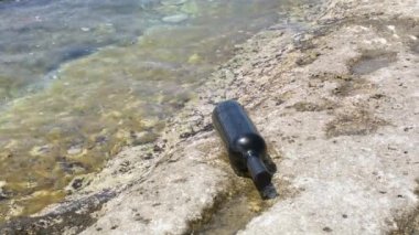 Bottle of wine on the rocky seashore. Caspian Sea. 07 June 2022 Year.