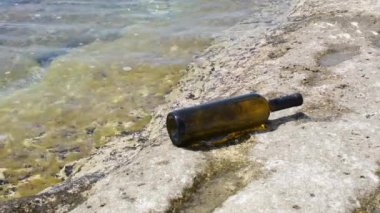 Bottle of wine on the rocky seashore. Caspian Sea. 07 June 2022 Year.
