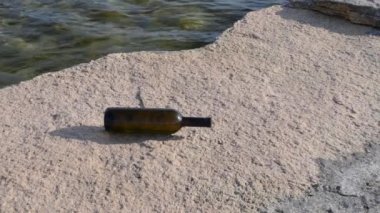 Bottle of wine on the rocky seashore. Caspian Sea. 07 June 2022 Year.