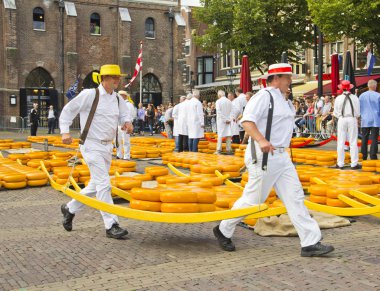 Carriers walking with many cheeses in Alkmaar, Holland clipart