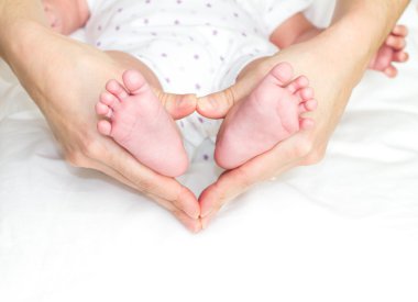 Holding bebeğin ayakları anne