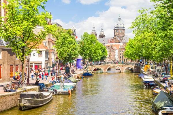 Turisti che passeggiano lungo un canale ad Amsterdam — Foto Stock