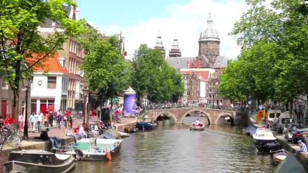 Туристы, идущие по каналу в Амстердаме — стоковое видео