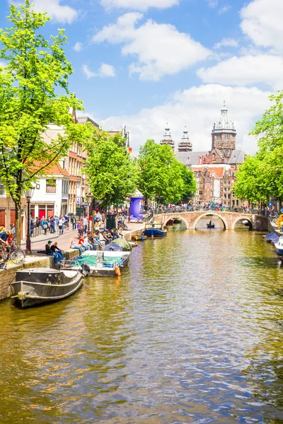 Amsterdam'da bir kanal tarafından yürüyen turist — Stok fotoğraf