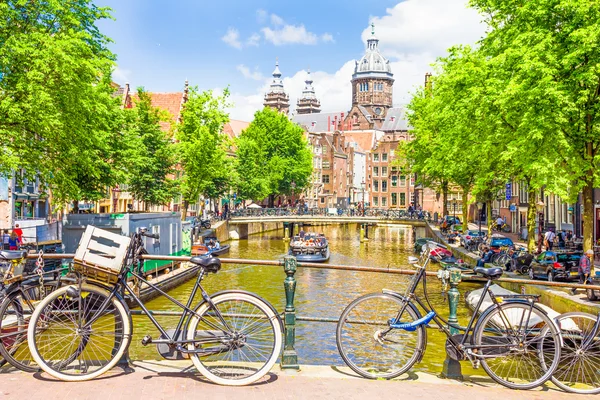 Amsterdam'da bir kanal tarafından yürüyen turist