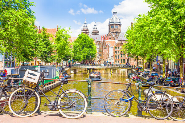 Tourists walking by a canal in Amsterdam