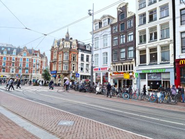 Amsterdam, Hollanda - 02 Ekim 2021: Amsterdam sokaklarında yürüyen turistler. Amsterdam Hollanda 'nın başkentidir ve bisiklet kültürünün merkezidir..