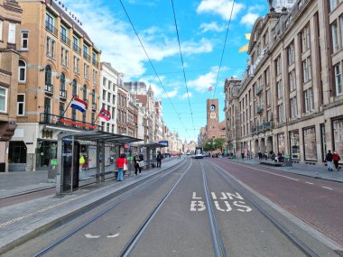 Amsterdam, Hollanda - 03 Ekim 2021: Nieuwezijds Voorburgwal caddesinde yürüyen insanlar. Cadde kuzeyden güneye, Merkez İstasyonu ve Baraj Meydanı 'nı birbirine bağlıyor..