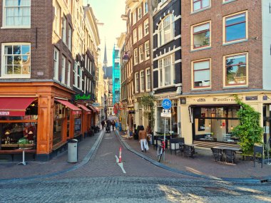 Amsterdam, Hollanda - 04 Ekim 2021: Amsterdam 'ın merkezinde yürüyen insanlar. Şehir çok çeşitli restoran, kafe ve teraslara ev sahipliği yapmaktadır..