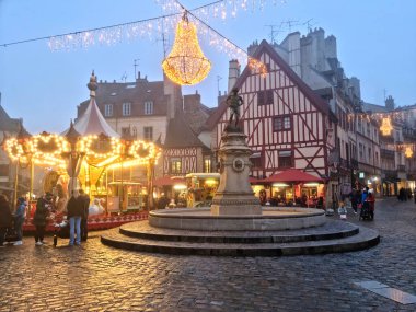 Dijon, France - 31 December, 2022: People walking in the Francois Rude square during Christmas time. Its architecture is a mix of Middle Age and Renaissance.