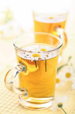 Papatya çiçekli bir fincan bitki çayı.