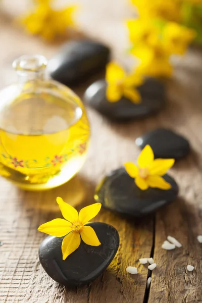 Wellness stones etherische olie en gele bloemen voor spa — Stockfoto