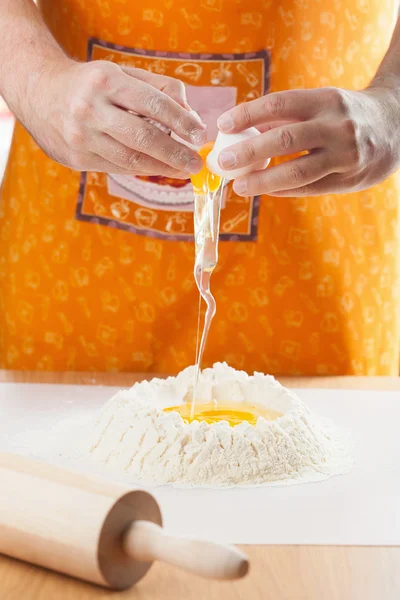 男の手の小麦粉に卵を割れ — ストック写真