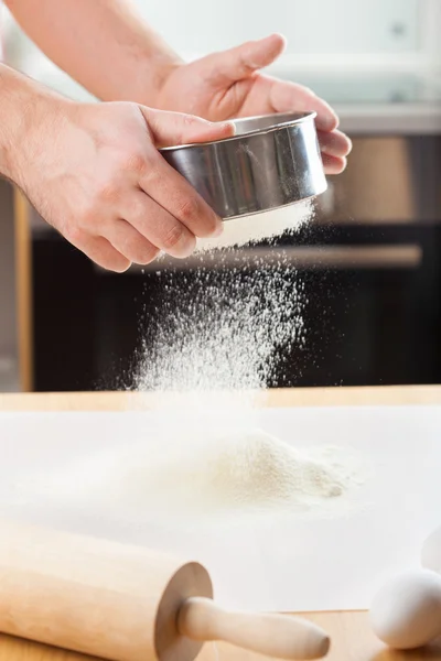 Mans manos tamizar la harina a través de un tamiz para hornear —  Fotos de Stock