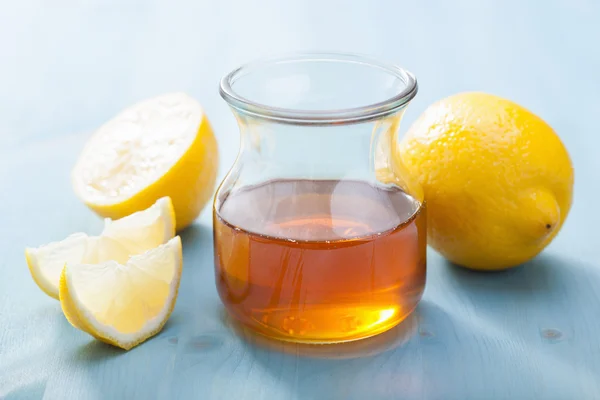 Honey and lemon over blue background — Stock Photo, Image