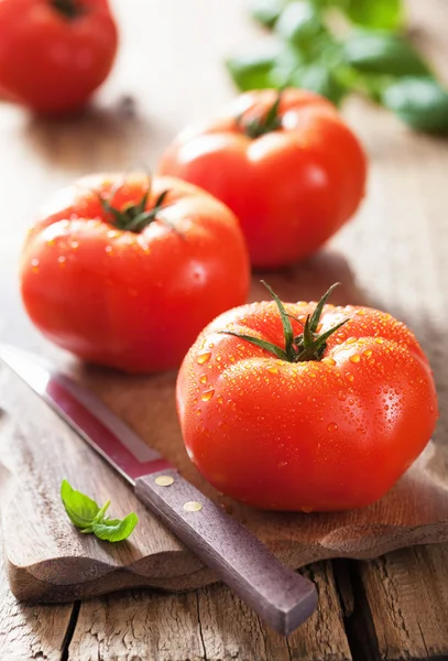 Tomates frescos en la tabla de cortar — Foto de Stock