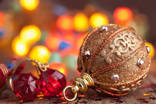 Goldene Weihnachtskugel über verschwommenem buntem Hintergrund — Stockfoto