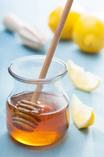Honey and lemon over blue background — Stock Photo, Image