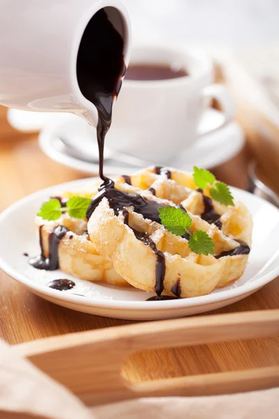 Pouring chocolate over belgian waffles for breakfast — Stock Photo, Image