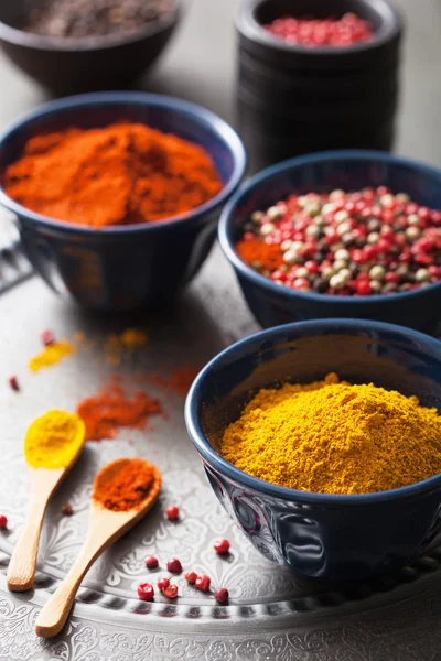 Spices in bowls: curry, pink and black pepper, paprika powder — Stock Photo, Image