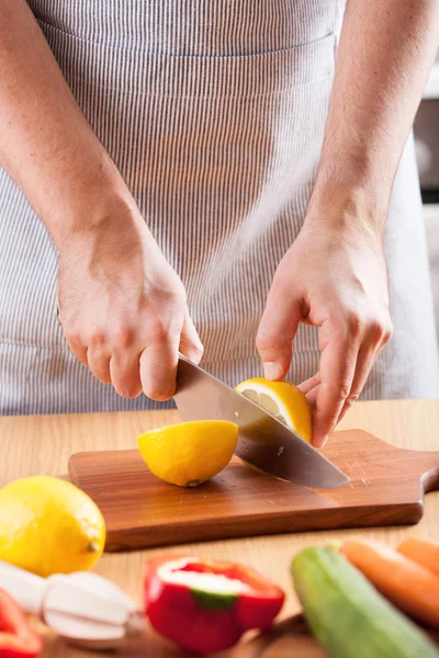 Chef-kok handen snijden citroen in keuken — Stockfoto