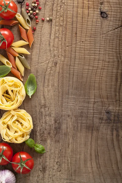 Pasta tomatoes basil frame on wooden background — Stock Photo, Image