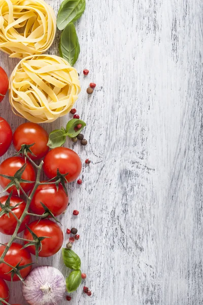 Pasta tomatoes basil frame on white wooden background — Stock Photo, Image