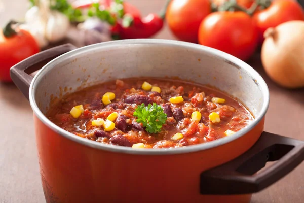 Mexikanska chili con carne i röda rustika gryta med ingredienser — Stockfoto