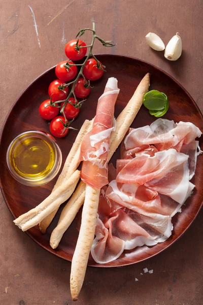 Włoskiego prosciutto szynka grissini chleb laski pomidora oliwa z oliwek — Zdjęcie stockowe