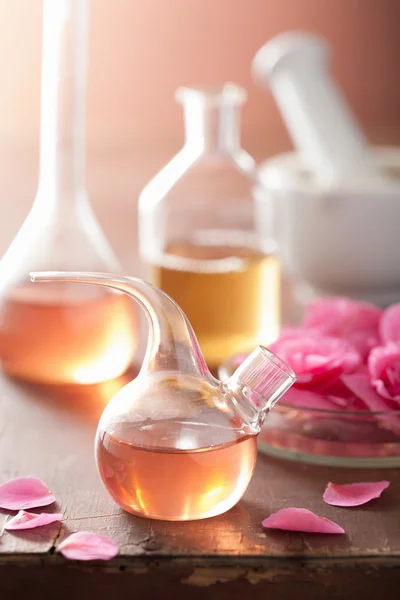 Aromatherapie en alchemie met roze bloemen — Stockfoto