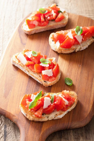 Bruschetta italiana con pomodori, parmigiano, aglio e olio d'oliva — Foto Stock