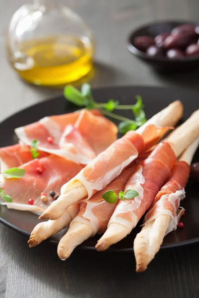 Prosciutto ham and grissini bread sticks. italian antipasto — Stock Photo, Image