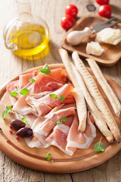 Prosciutto ham and grissini bread sticks. italian antipasto — Stock Photo, Image