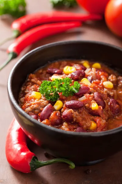 Mexican chili con carne in black plate with ingredients — Stock Photo, Image
