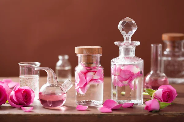 Conjunto de alquimia y aromaterapia con flores de rosas y frascos —  Fotos de Stock