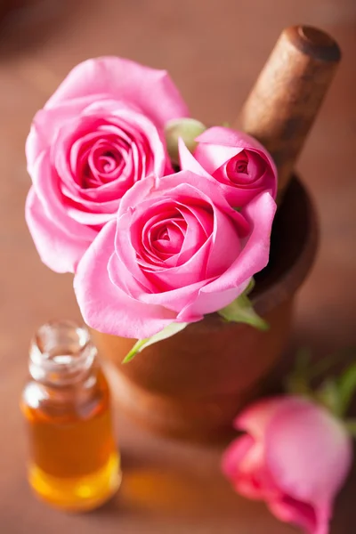 Mortero con flores de rosa y aceite esencial para aromaterapia y — Foto de Stock