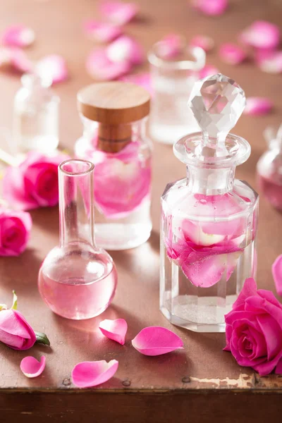 Alchemy and aromatherapy set with rose flowers and flasks — Stock Photo, Image