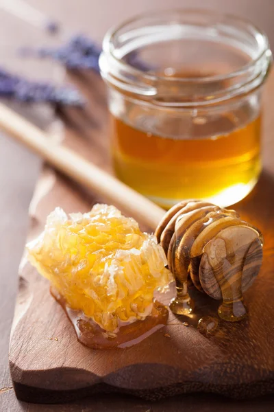 Trempette en nid d'abeille et pot en verre sur fond en bois — Photo