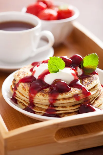 Блинчики с вишневым джемом и сливками на завтрак — стоковое фото