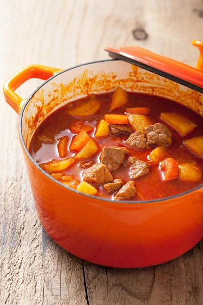 Beef stew with potato and carrot in red casserole — Stock Photo, Image