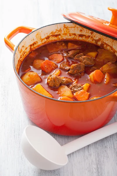 Beef stew with potato and carrot in red casserole — Stock Photo, Image