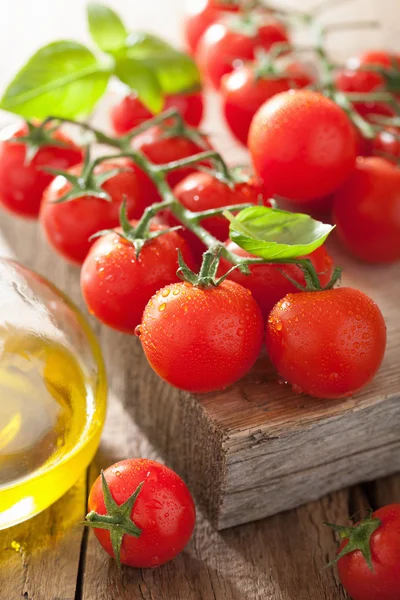 Kerstomaten basilicum en olijfolie op houten ondergrond — Stockfoto