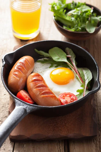Fried egg sausages tomatoes in pan for breakfast — Stock Photo, Image