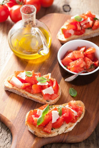 Bruschetta italiana con tomates, parmesano, ajo y aceite de oliva — Foto de Stock