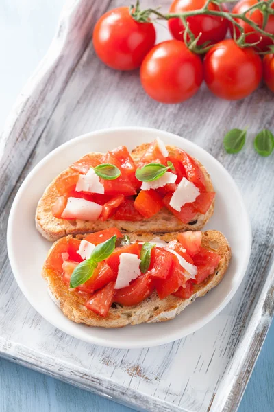 Bruschetta italiana con pomodori, parmigiano, aglio e olio d'oliva — Foto Stock
