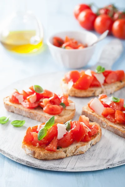 Bruschetta italiana con tomates, parmesano, ajo y aceite de oliva — Foto de Stock