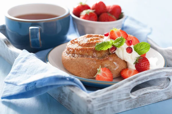 Rouleau de cannelle sucrée avec crème et fraise pour le petit déjeuner — Photo